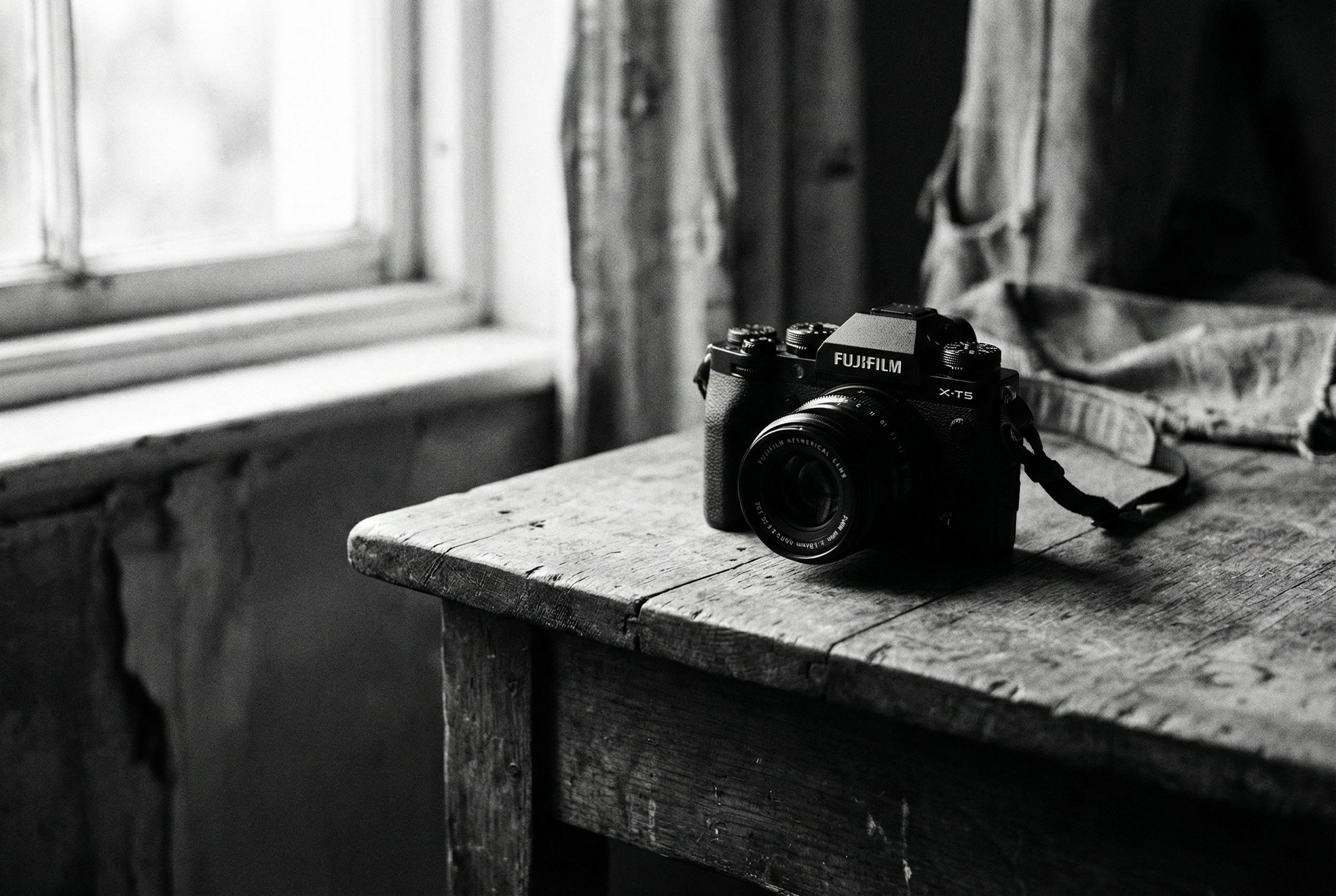 Fujifilm X-T5 on wooden table, black and white