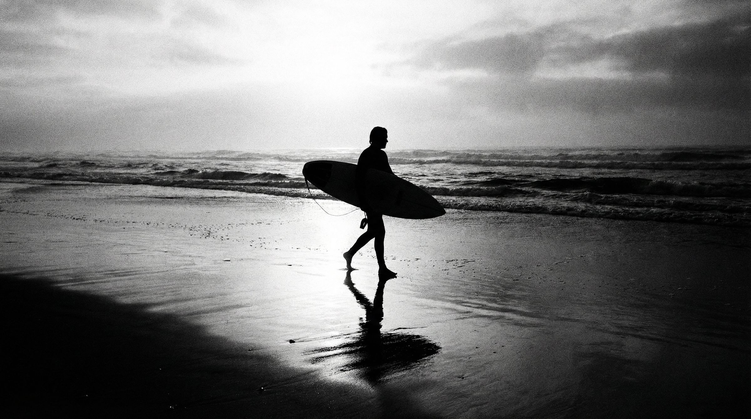 Surfer silhouette at dawn, black and white