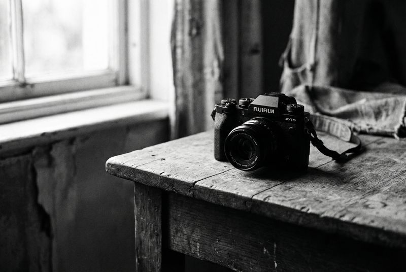 Fujifilm X-T5 on wooden table, black and white
