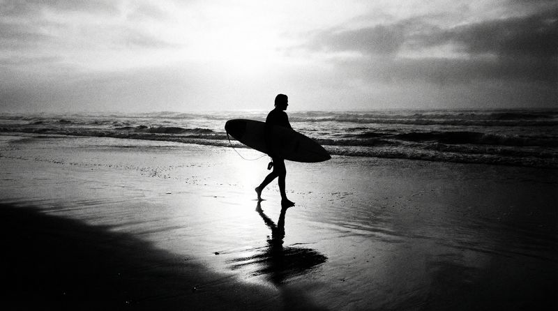 Surfer silhouette at dawn, black and white